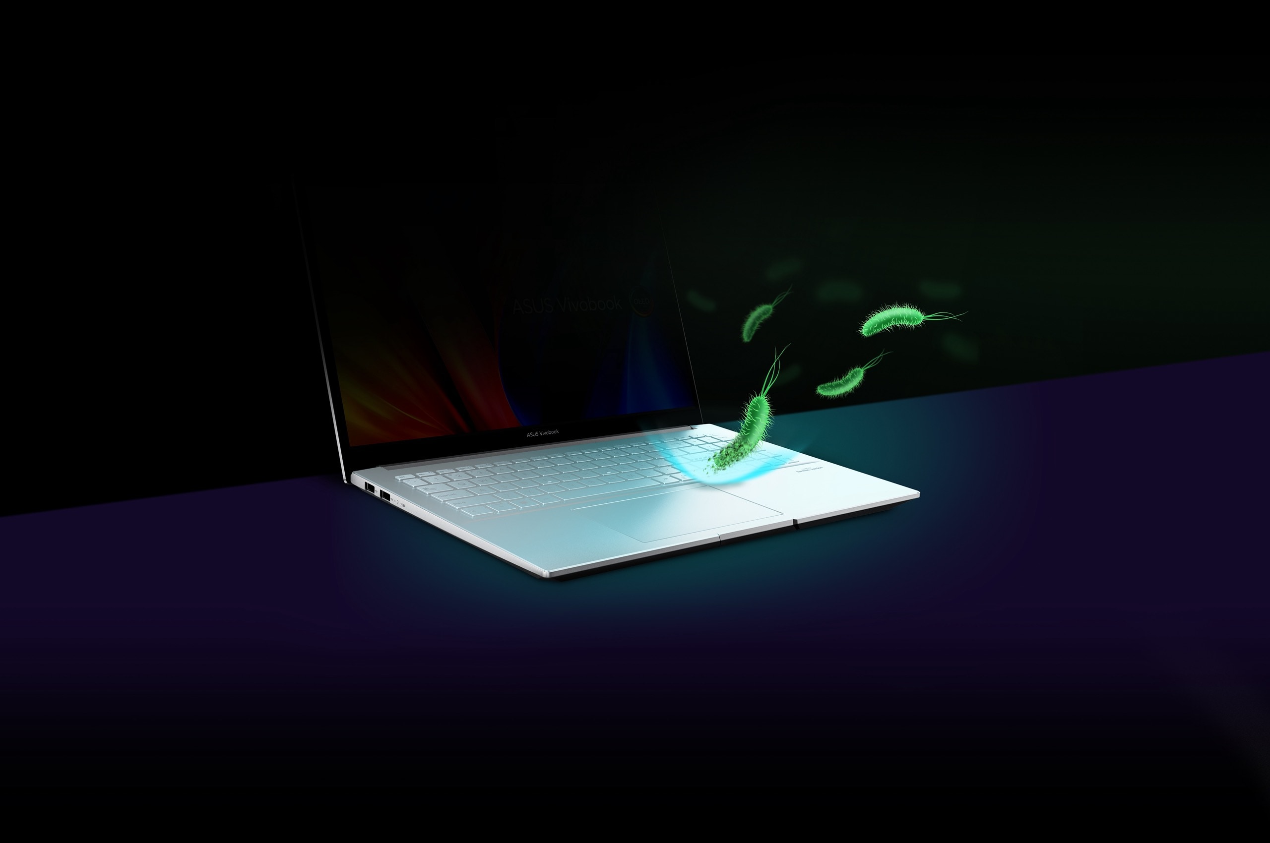 Le clavier d'un ordinateur portable traité par ASUS Antibacterial Guard avec des images 3D de bactéries rebondissant sur lui montre l'effet de son inhibition bactérienne.