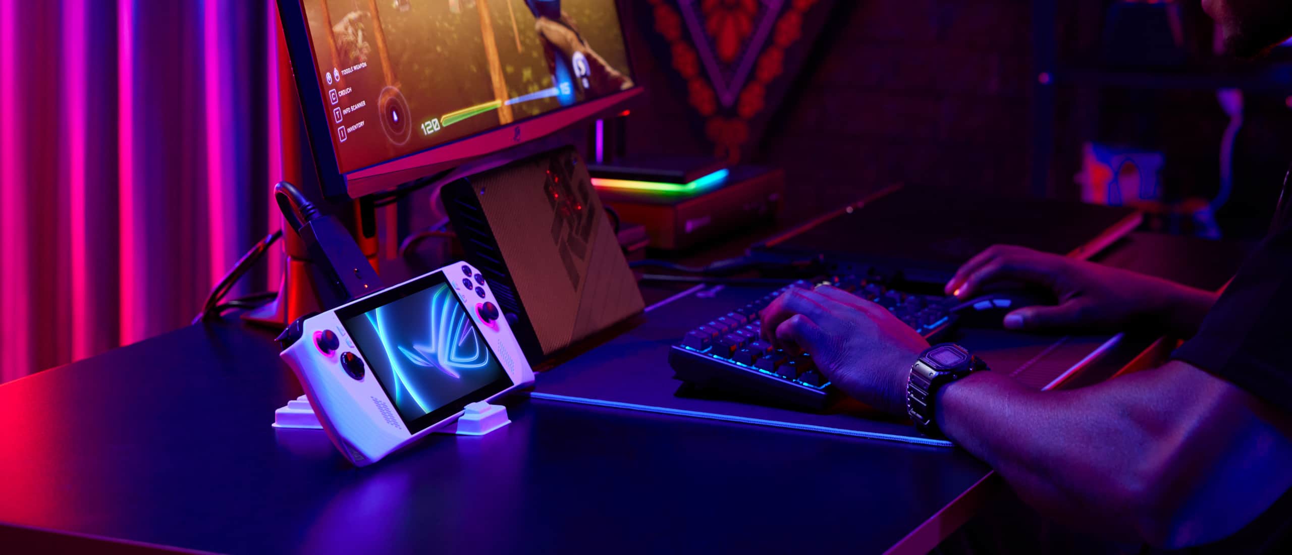 Personne assise à un bureau, équipée d'un clavier, d'une souris et d'un écran externe, et dont la console Ally est connectée au système et à un XG Mobile, en train de jouer à un jeu de compétition.
